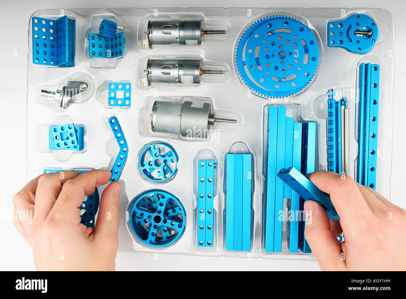 Unpacking DIY kit above view. Hands take metal part of rc model Stock Photo