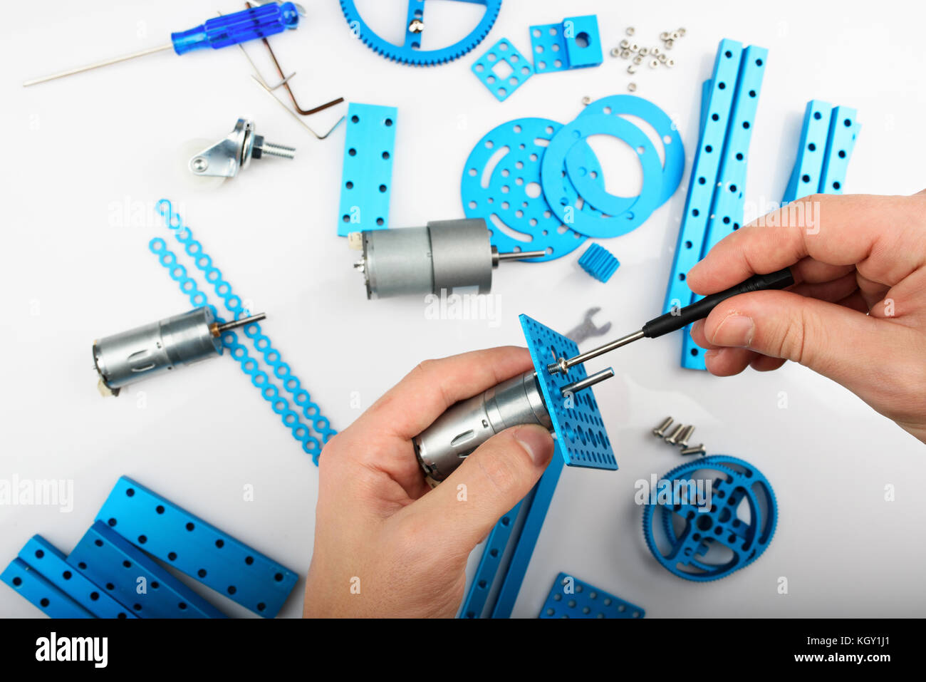 Modeling hobby concept. Hands putting screw in metal rc car parts Stock Photo