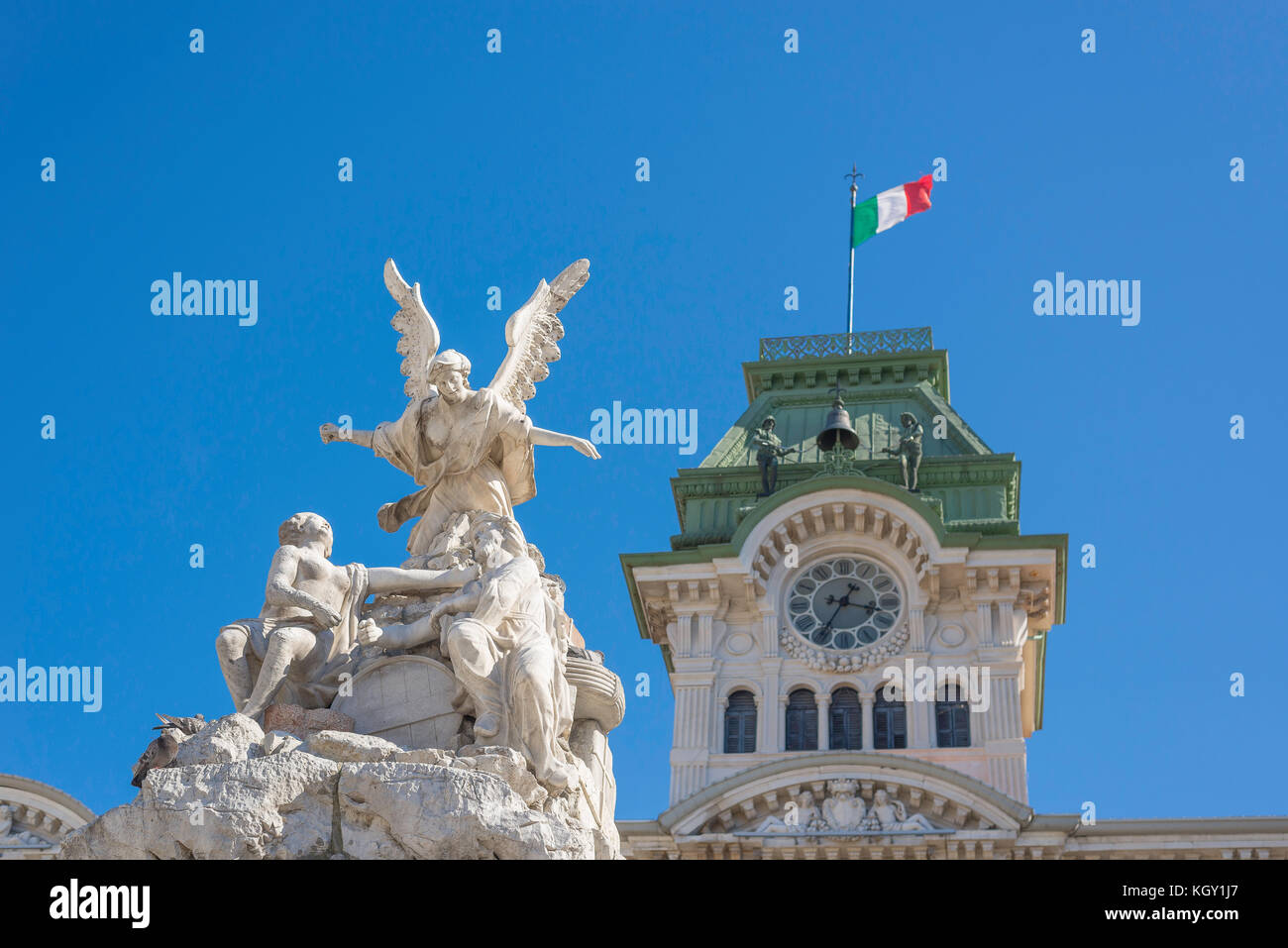 Trieste city, detail of the angel statue on top of the Fountain of Four Continents and the Town Hall clock tower, Piazza dell Unita d'Italia, Trieste. Stock Photo