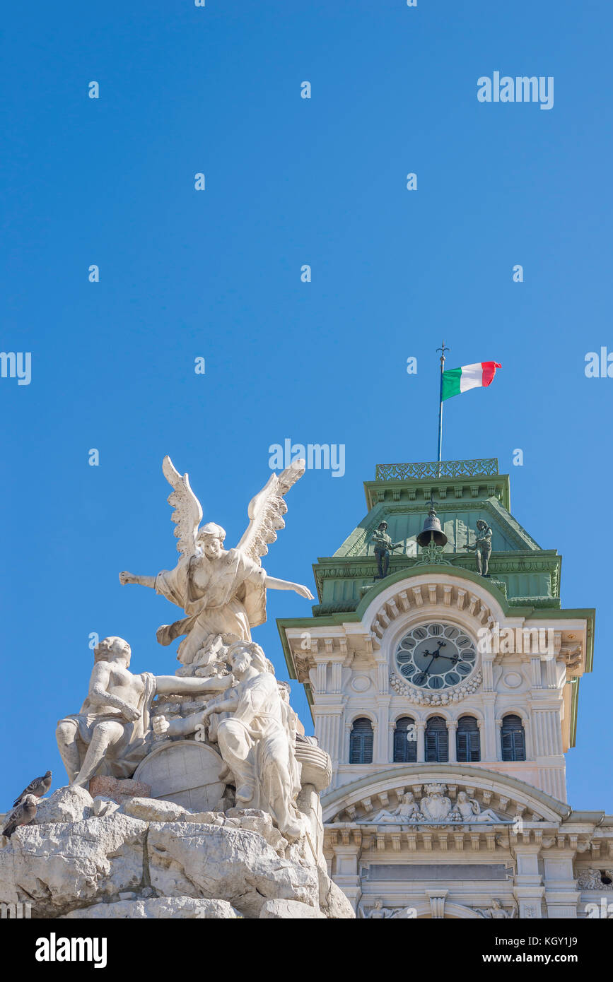 Trieste Italy fountain, detail of angel statue on top of the Fountain of Four Continents and Town Hall clock tower, Piazza Unita d'Italia, Trieste. Stock Photo