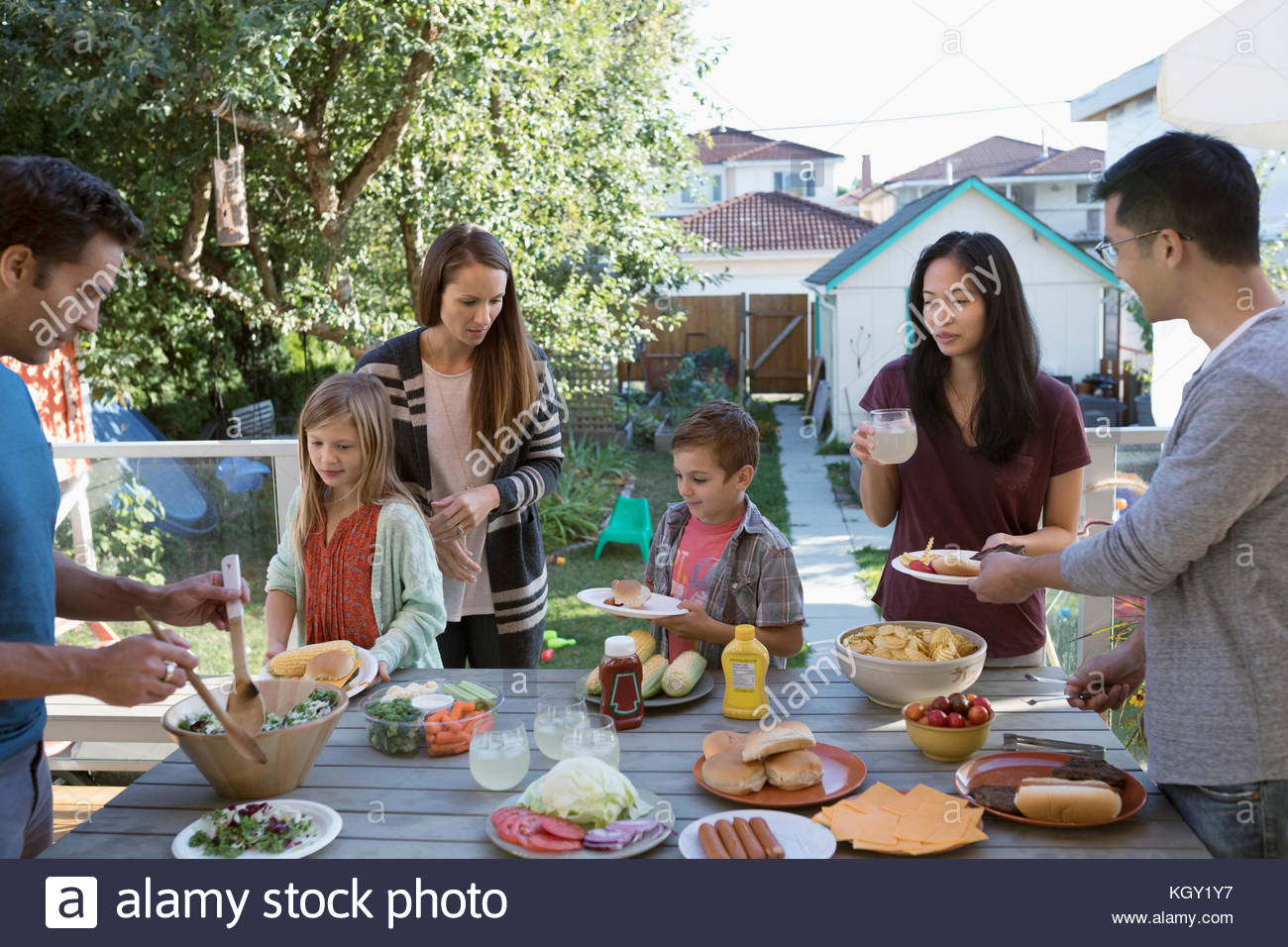 Neighbor families enjoying barbecue on patio Stock Photo