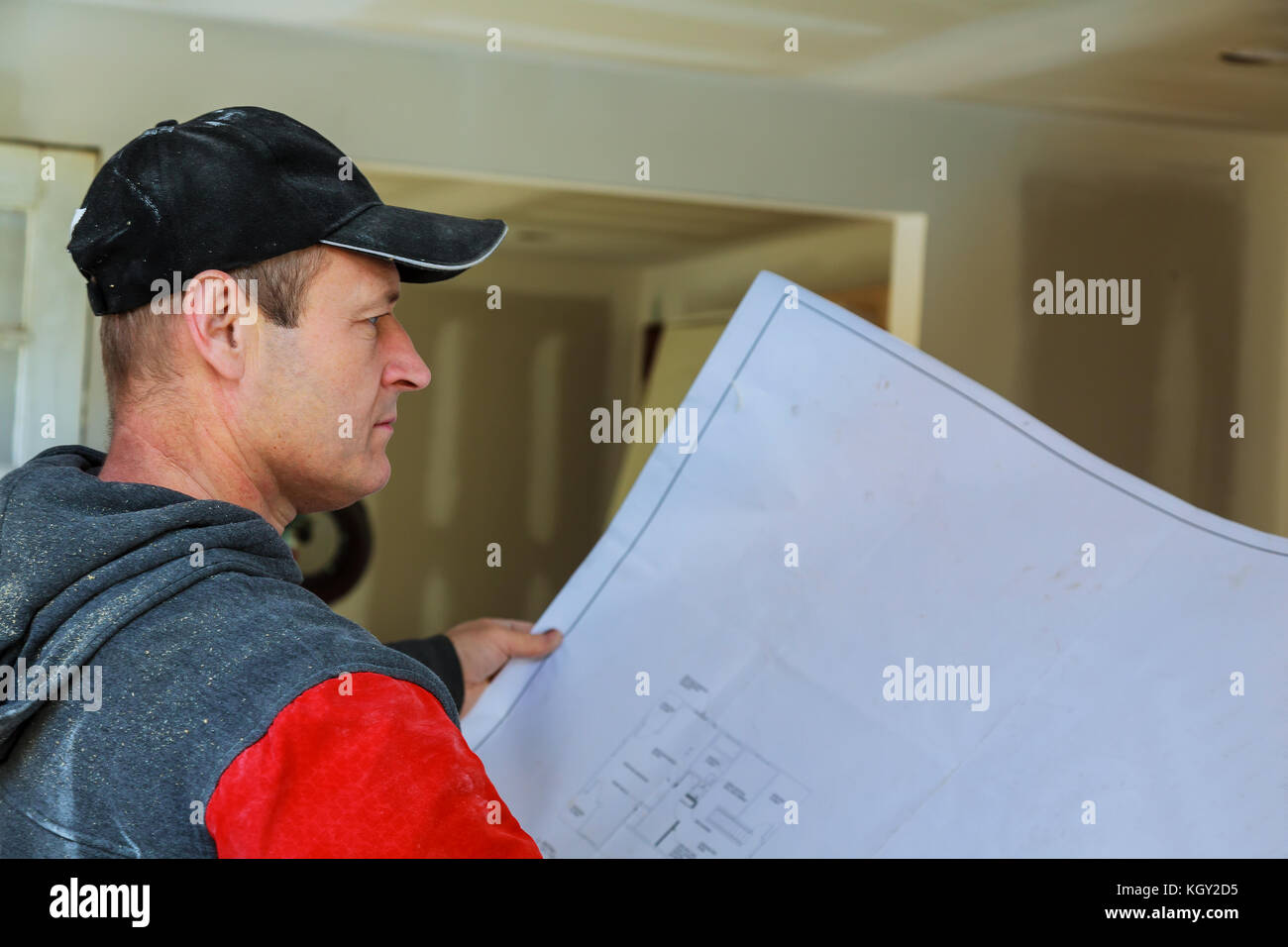 Profile shot of a young bearded male architect working on blueprints sitting at his desk at the office copyspace building plans construction project e Stock Photo