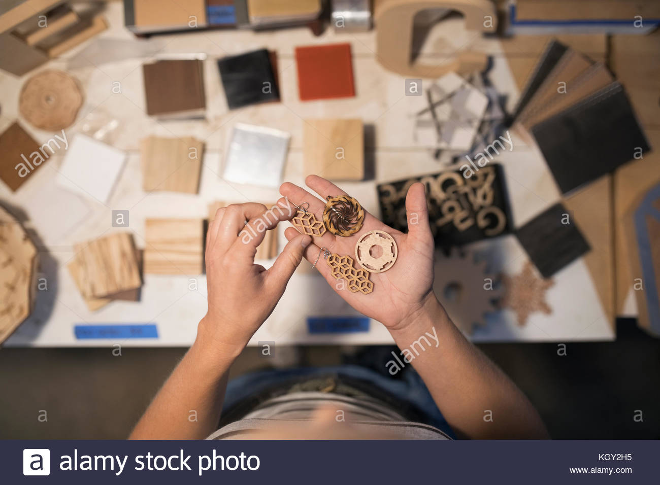 View from above female craftswoman examining laser cut wood pieces