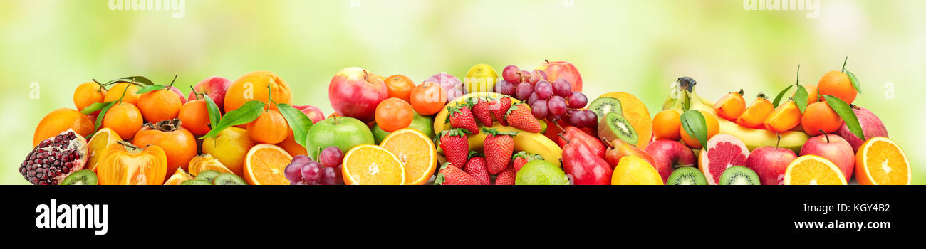 Panoramic wide photo of fresh fruits for skinali on a blurred green background. Stock Photo