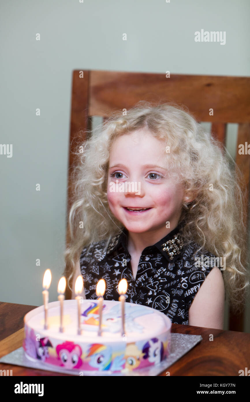 Girl smiling with candles on birthday cake Stock Photo