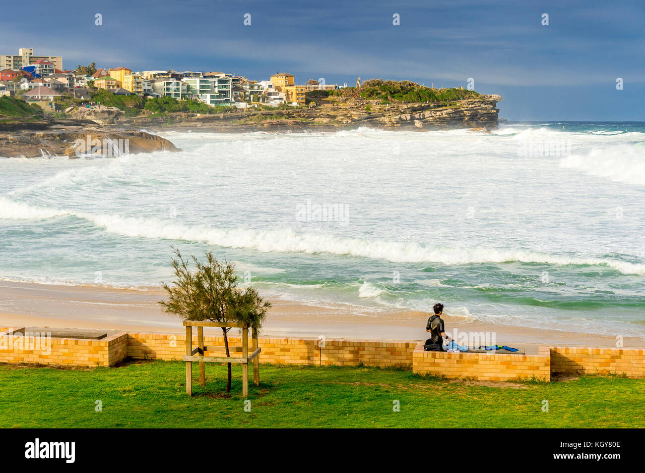 A surfer prepares while watching massive surf conditions at Bronte Beach in Sydney, NSW, Australia Stock Photo