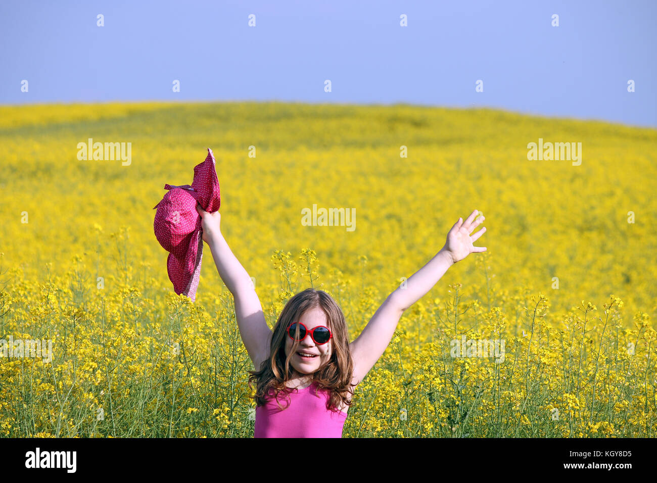 happy little girl on yellow flowers field summer season Stock Photo - Alamy