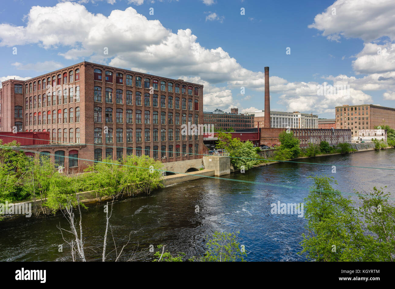 View of mill buildings and a smoke stack along the banks of the Merrimack River in the city of Lawrence, Massachusetts. Stock Photo