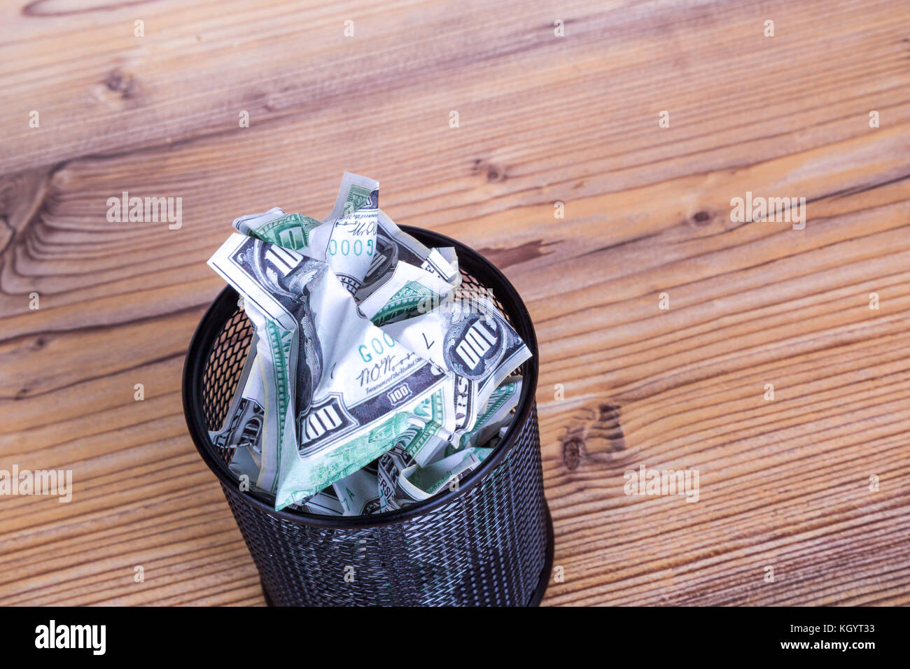 Dollar banknotes crumpled inside garbage basket, rubbish bin focused on ...