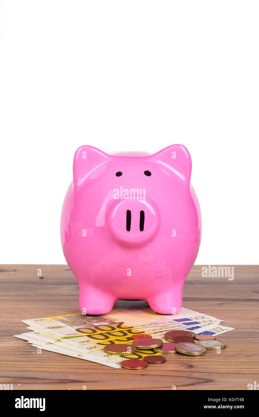 Piggy bank with stack of two hundred euro banknotes and coins on wooden ...
