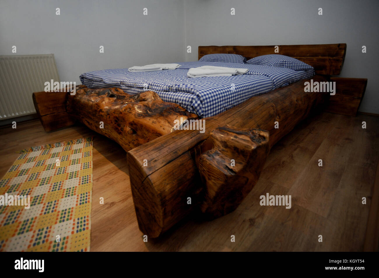 Old Wooden Rustic Bed With Blue Sheets Stock Photo