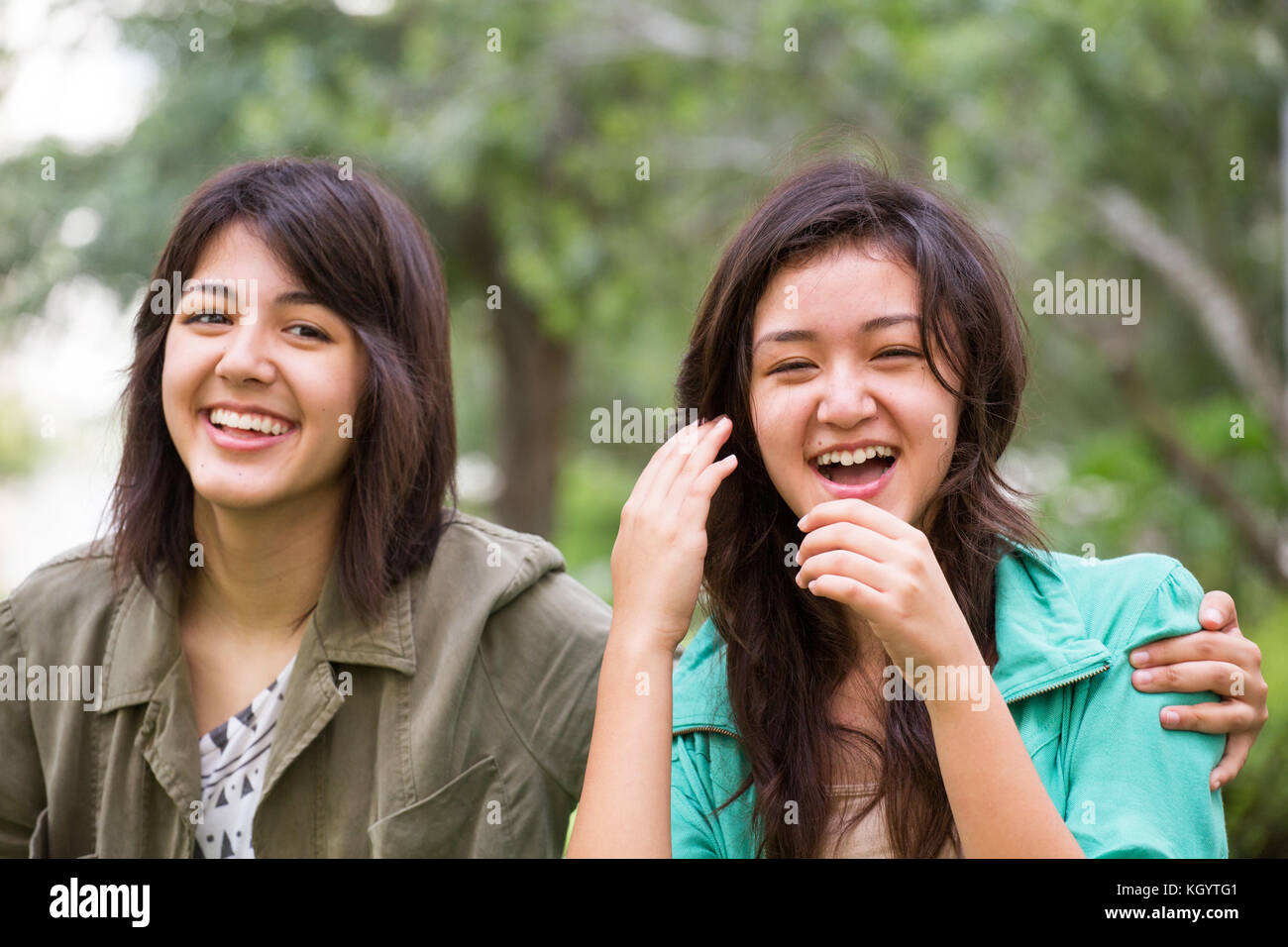 Asian mother laughing and huging her daughters. Stock Photo