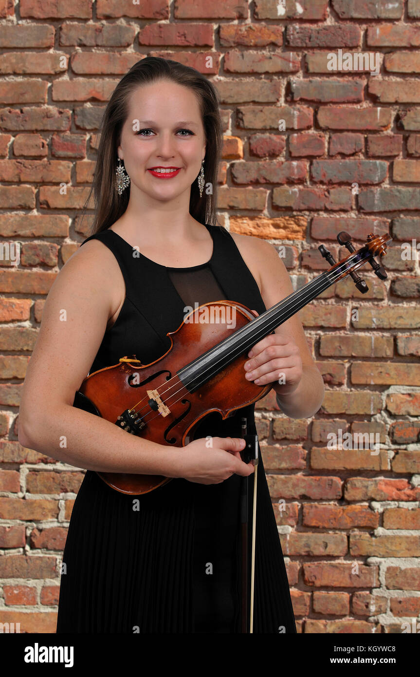 Beautiful young woman holding a violin classical instrument Stock Photo