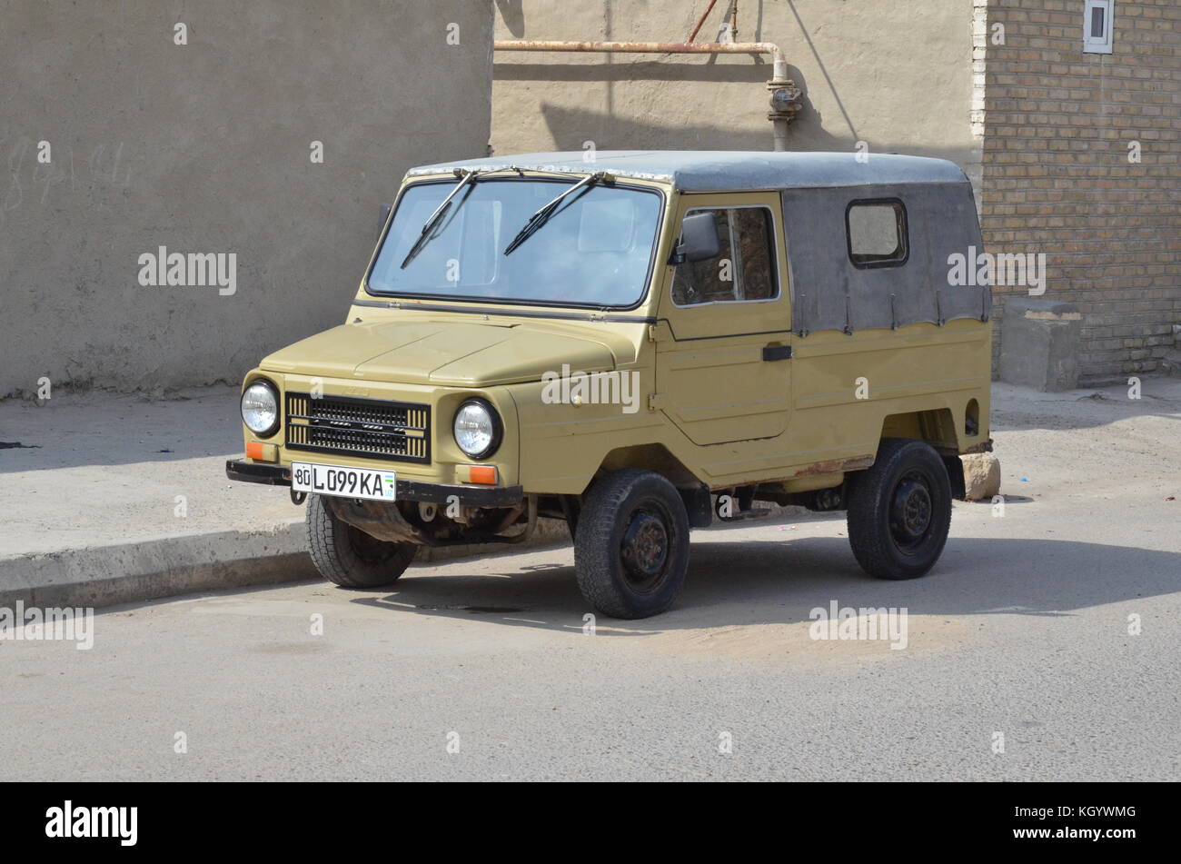A beige Russian pick up truck with windshield wipers attached to the roof in Bukhara, Uzbekistan. Stock Photo