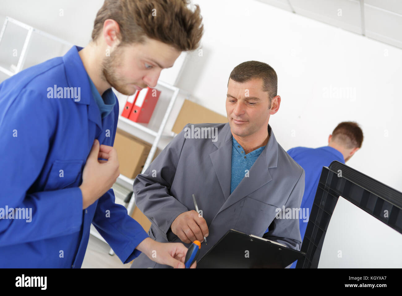 mechanic and apprentice working on car with computer Stock Photo - Alamy