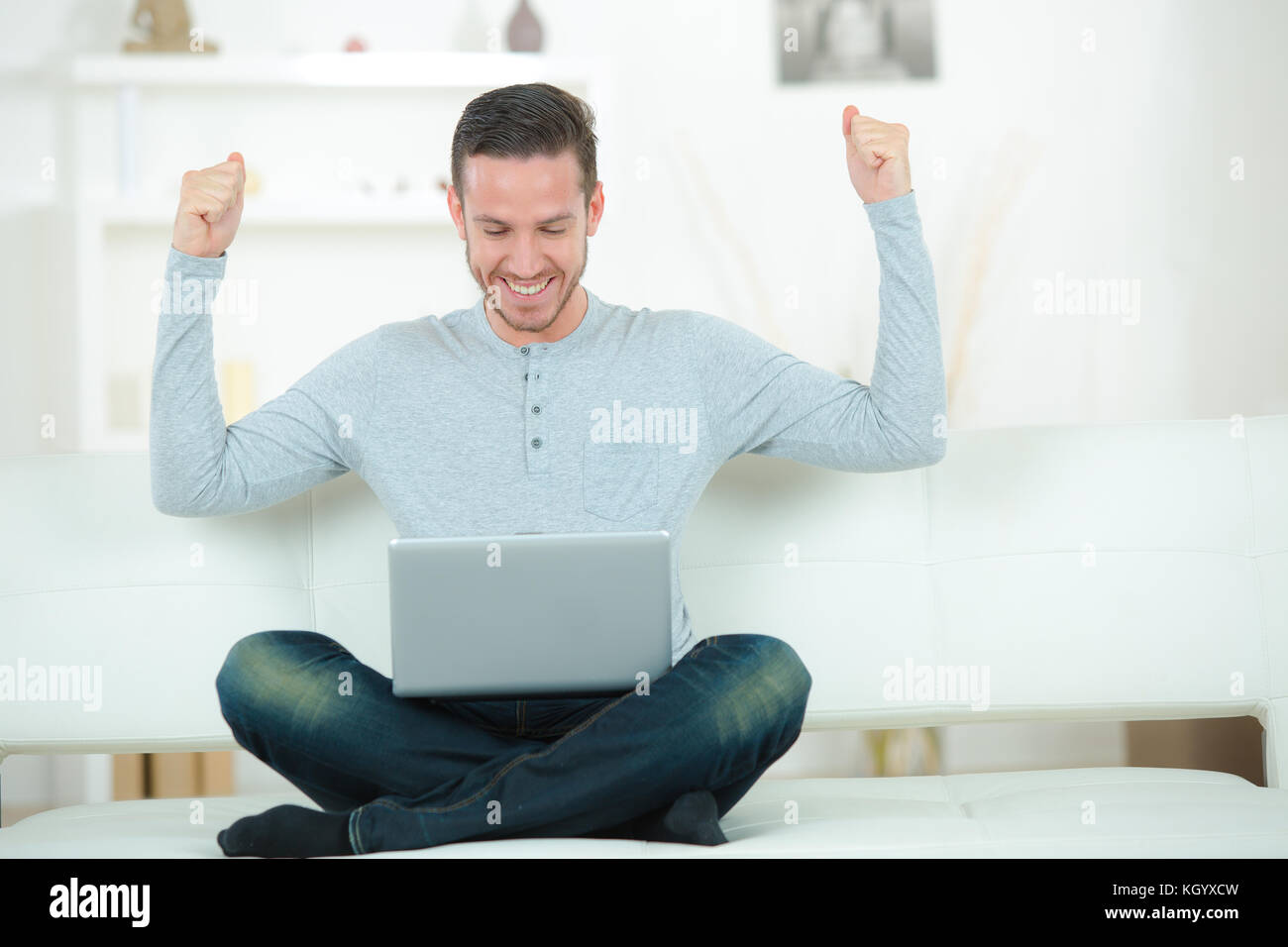 man sitting on sofa with arms up posture Stock Photo Alamy