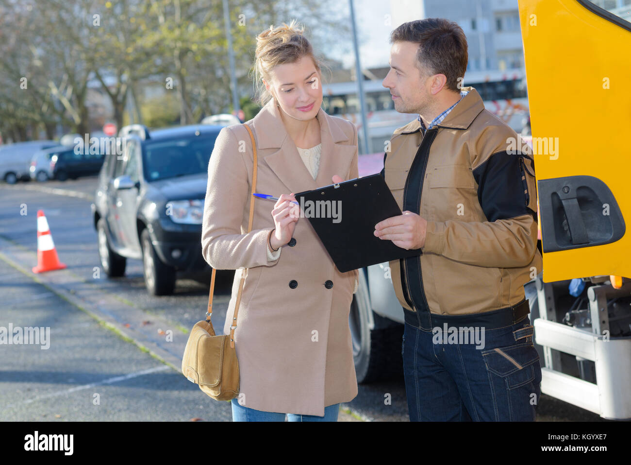tow truck driver talking with female client Stock Photo - Alamy
