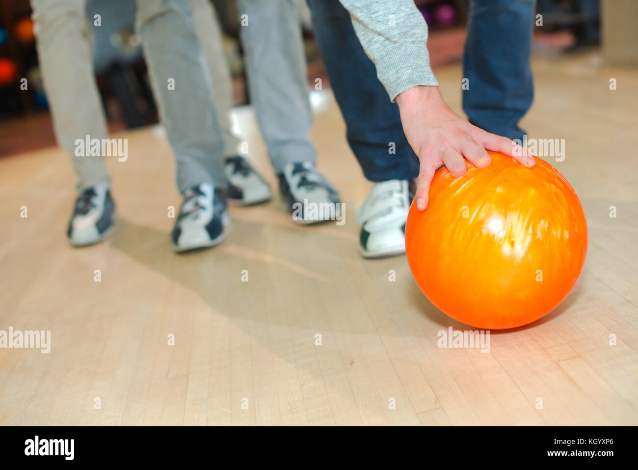 Man leaning down to pick up bowling ball Stock Photo Alamy