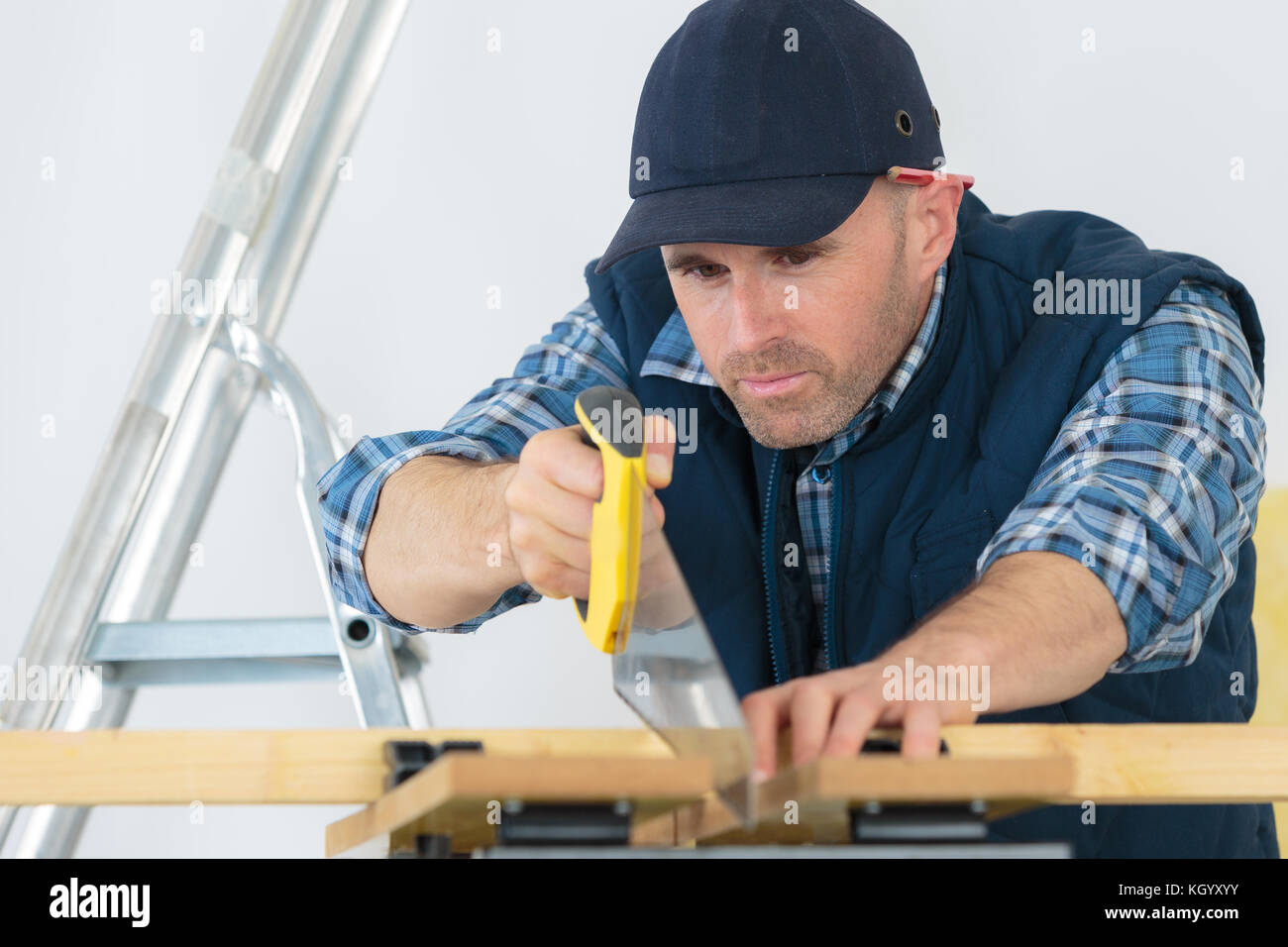 Плотник пилит. Столяр. Мужчина пилит. Плотник распиливает доску. Пила плотника.