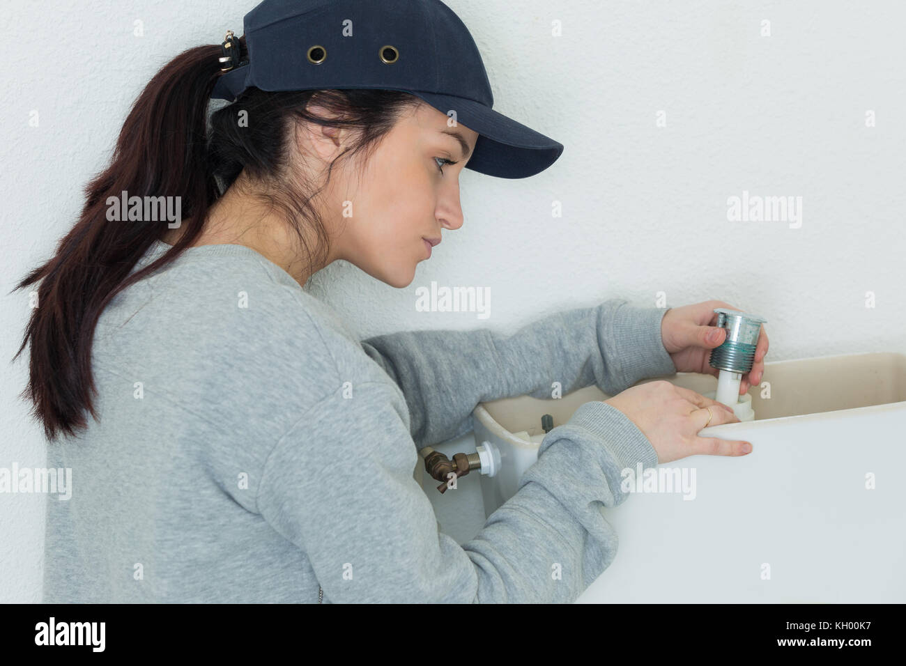female plumber fixing toilet flush Stock Photo Alamy