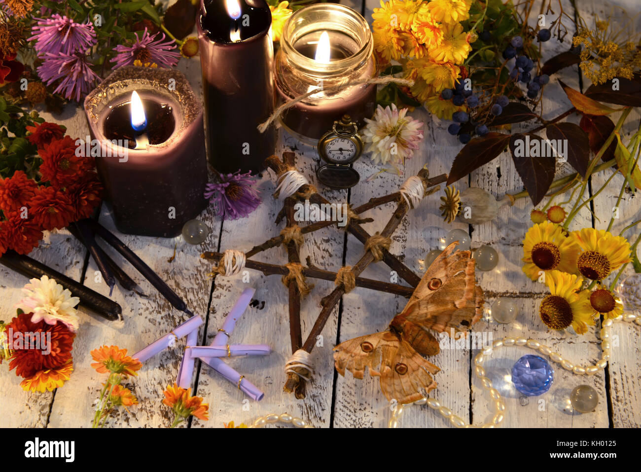 Wooden pentagram with moth, black candles and flowers on planks Stock ...
