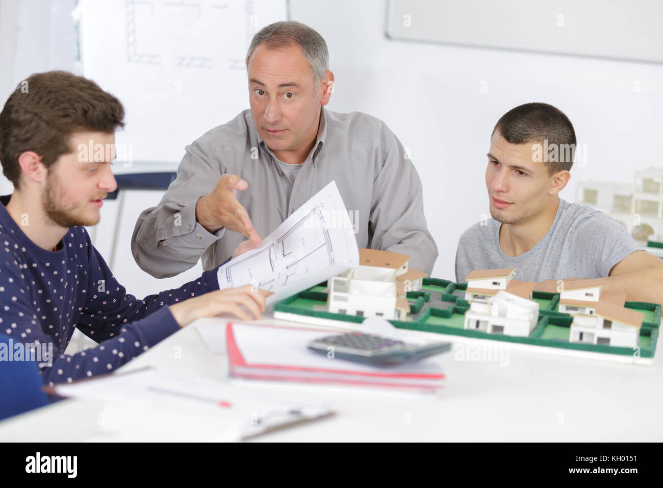 Architects with scale drawings and model development Stock Photo - Alamy