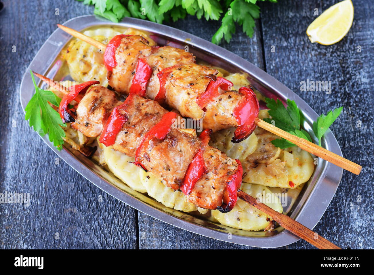 Chicken fillet with sweet paprika grilled with fried potato on a metal plate on a wooden background. Healthy eating concept Stock Photo