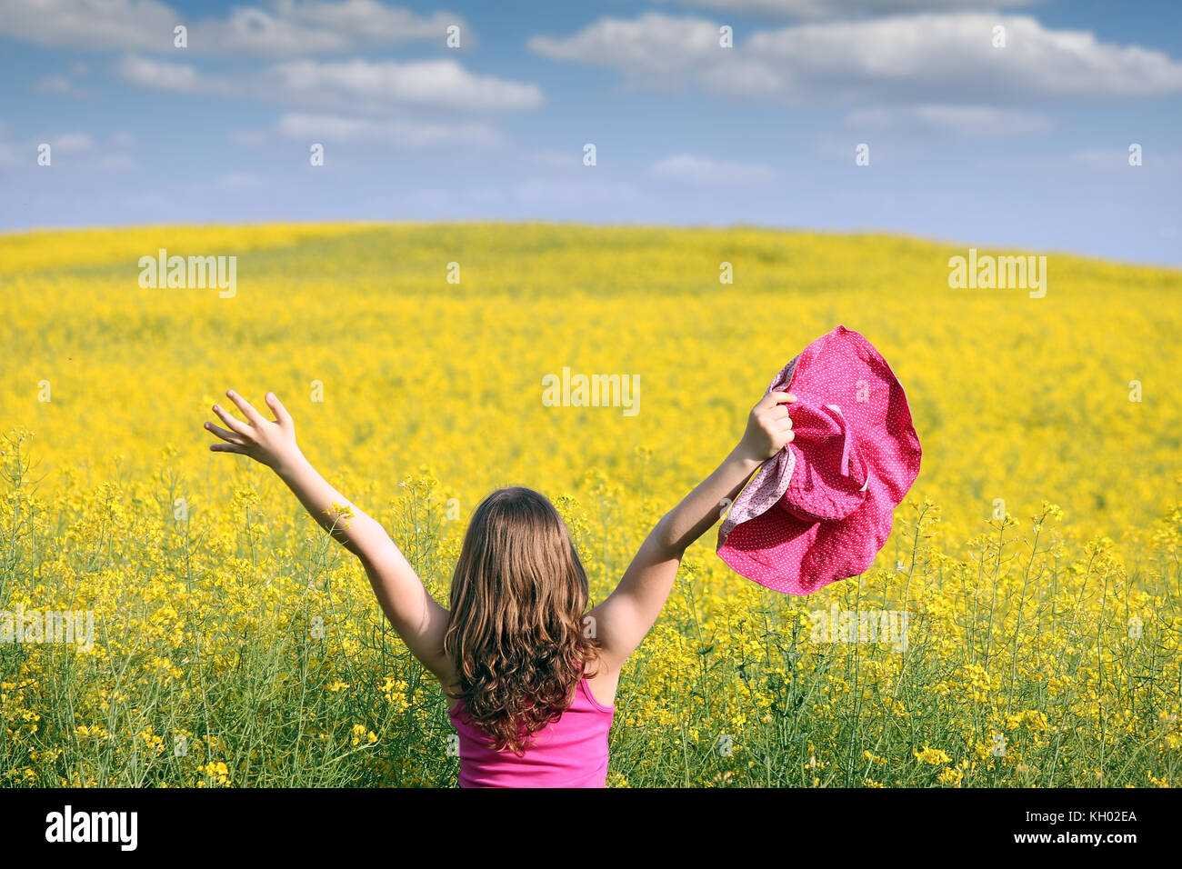 little girl with hands up on field Stock Photo - Alamy
