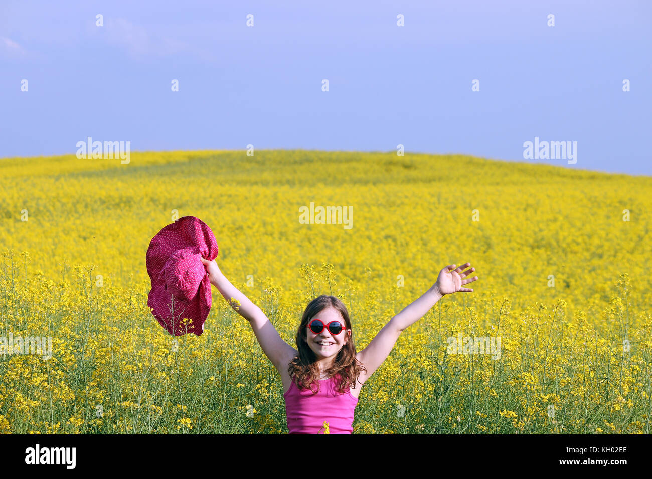 little girl with hands up on yellow flowers field summer season Stock ...