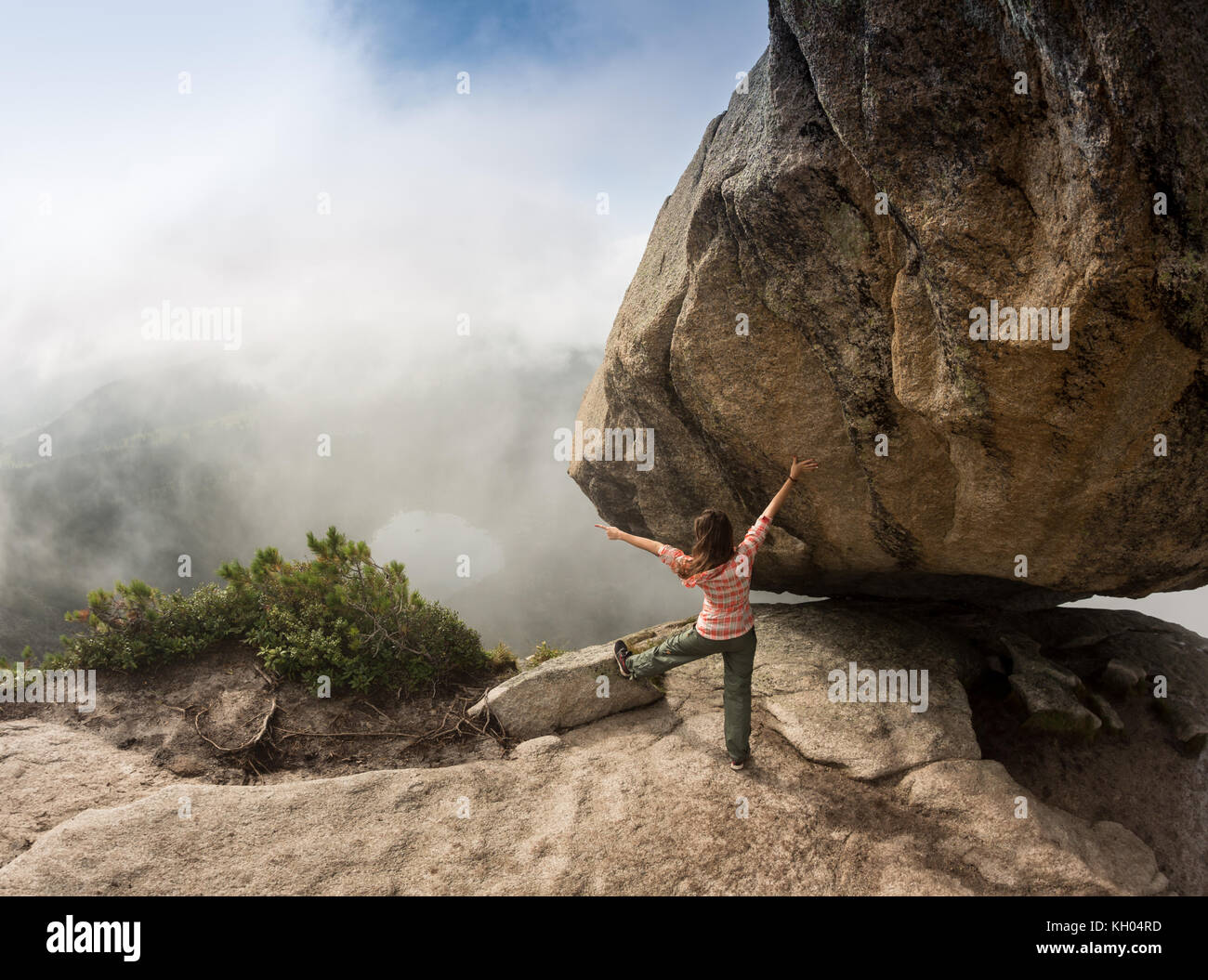 Climber is bouldering in nature. Girl climbs on a big stone. Woman