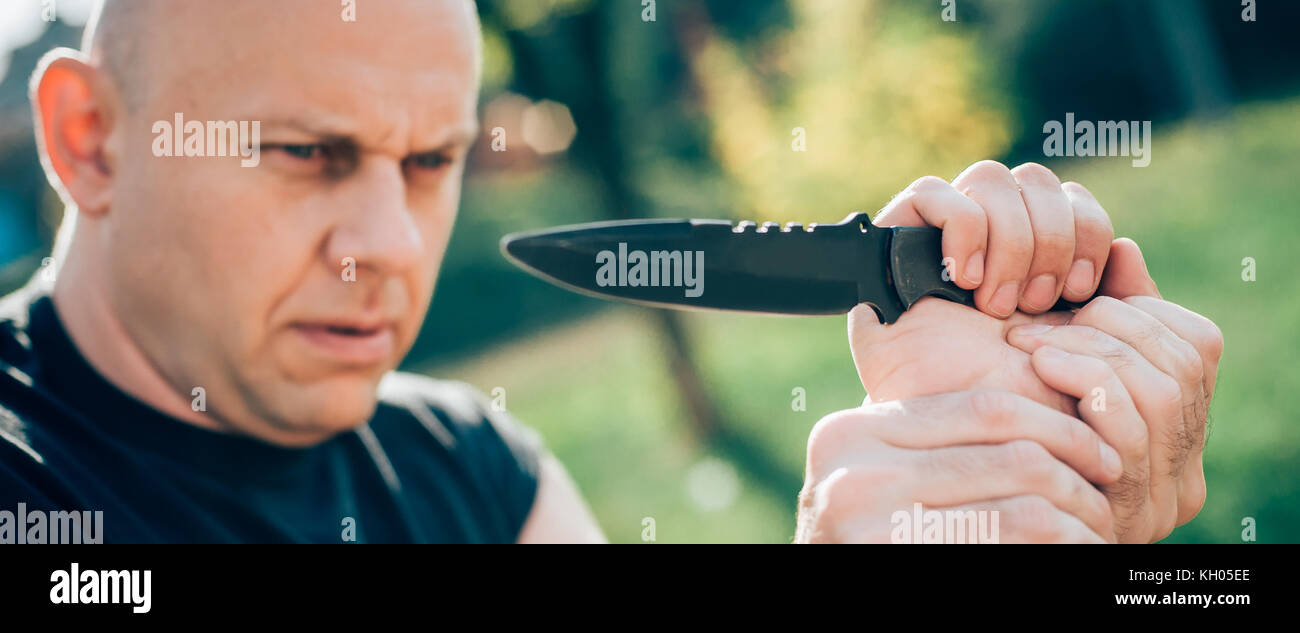 Kapap instructor demonstrates martial arts self defense knife attack  disarming technique against threat and knife attack. Weapon retention and  disarm Stock Photo - Alamy