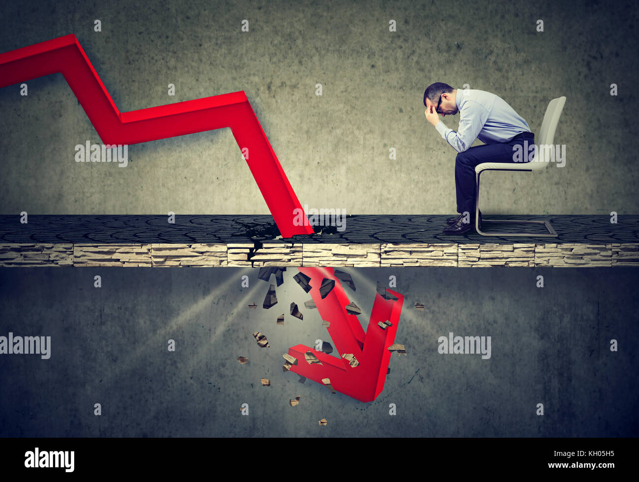 Depressed business man looking down at the falling red arrow going ...