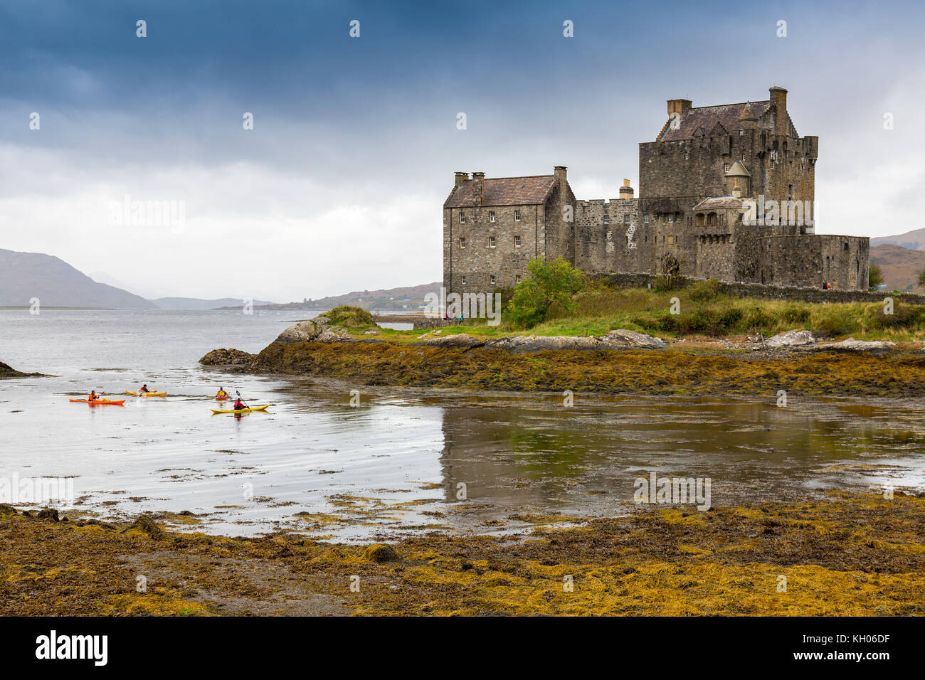 Sea kayakers at Eilean Donan, a 13th century castle on an island at the junction of Lochs Duich, Long and Alsh near Kyle of Lochalsh, Scotland, UK Stock Photo