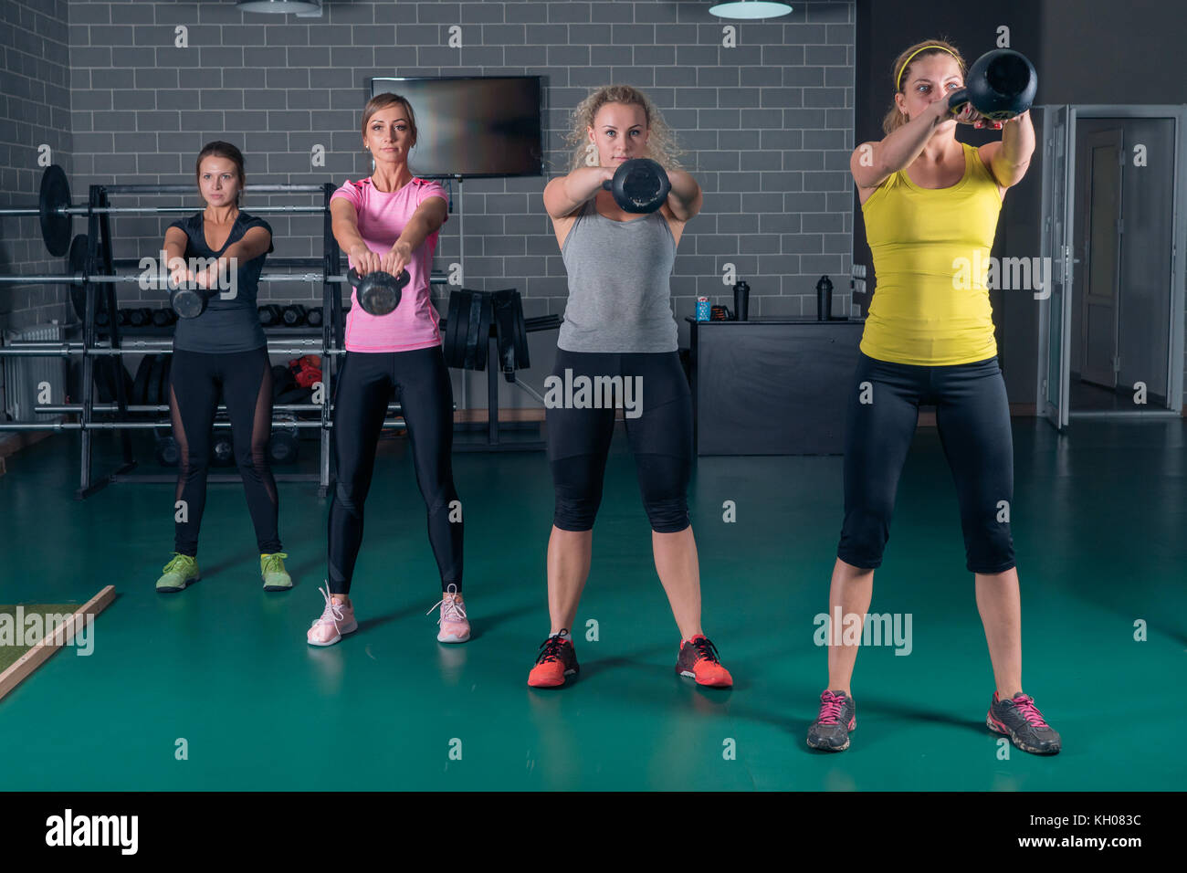 Young athletes train with weights in the gym. Kettlebell lifting Stock