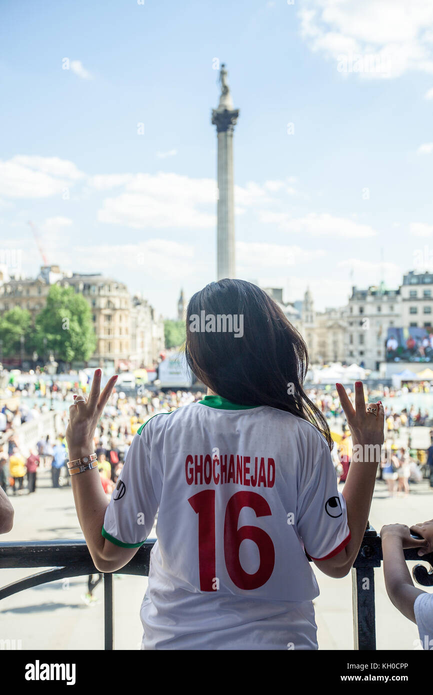 An Iranian woman says “peace” and wears the jersey of the Iranian national team player Reza Ghoochannejhad. UK 12/06 2014. Stock Photo