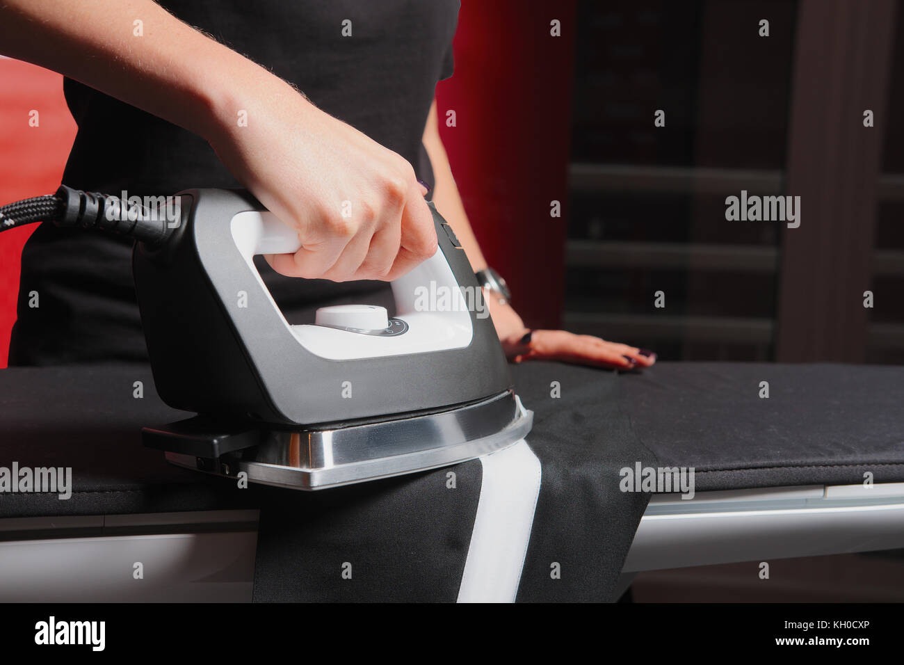 Ironing clothes. Hand holding iron with steam Stock Photo Alamy