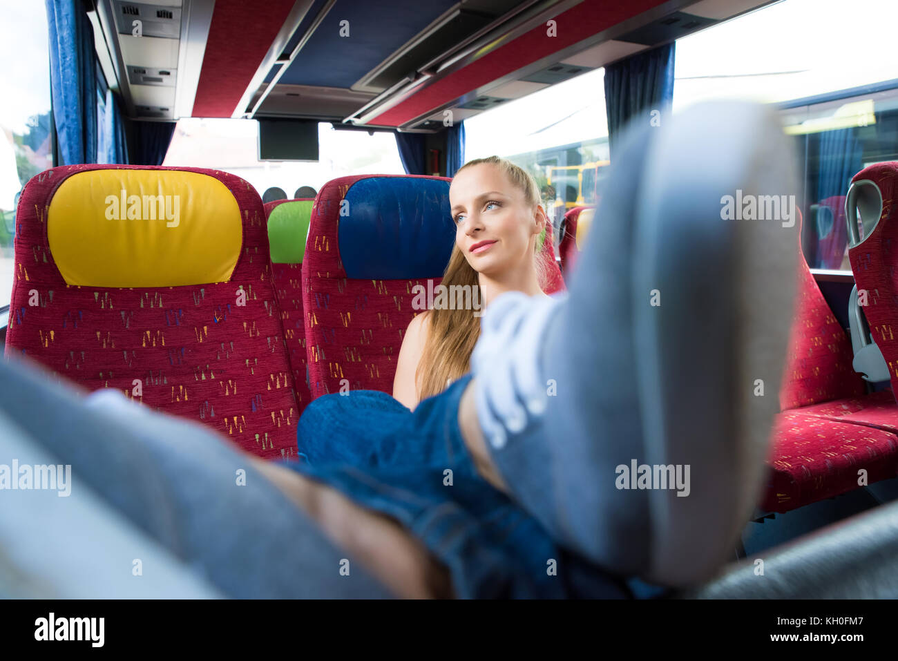 A young woman sitting comfortably on the bus Stock Photo Alamy