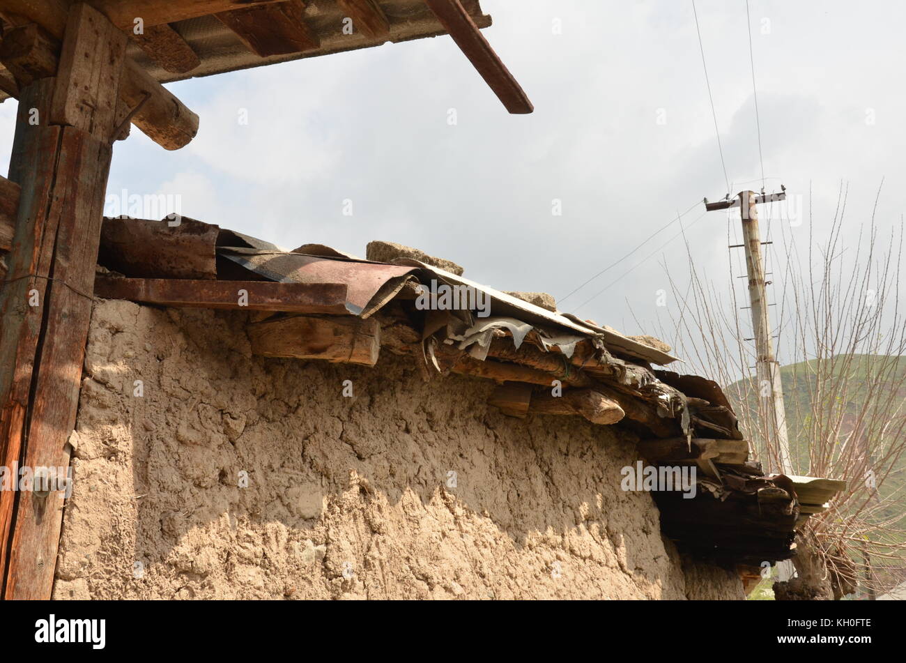 detail of a Tajik roof in a small village. House with clay dirt wall and wooden roof in Tajikistan. Stock Photo