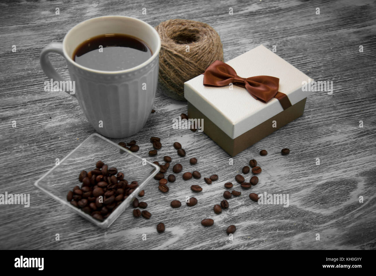 hank of threads, gift box, coffee beans and cup of cofee on gray Stock Photo