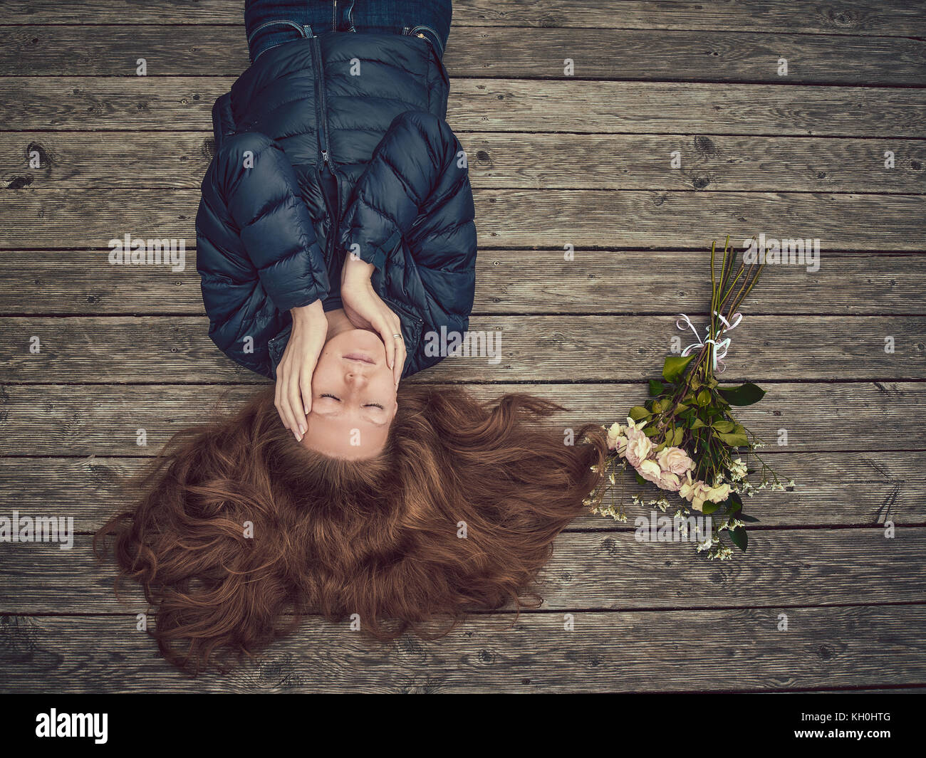 A Girl With Thick Red Hair Lies On A Wooden Floor She Is Dressed