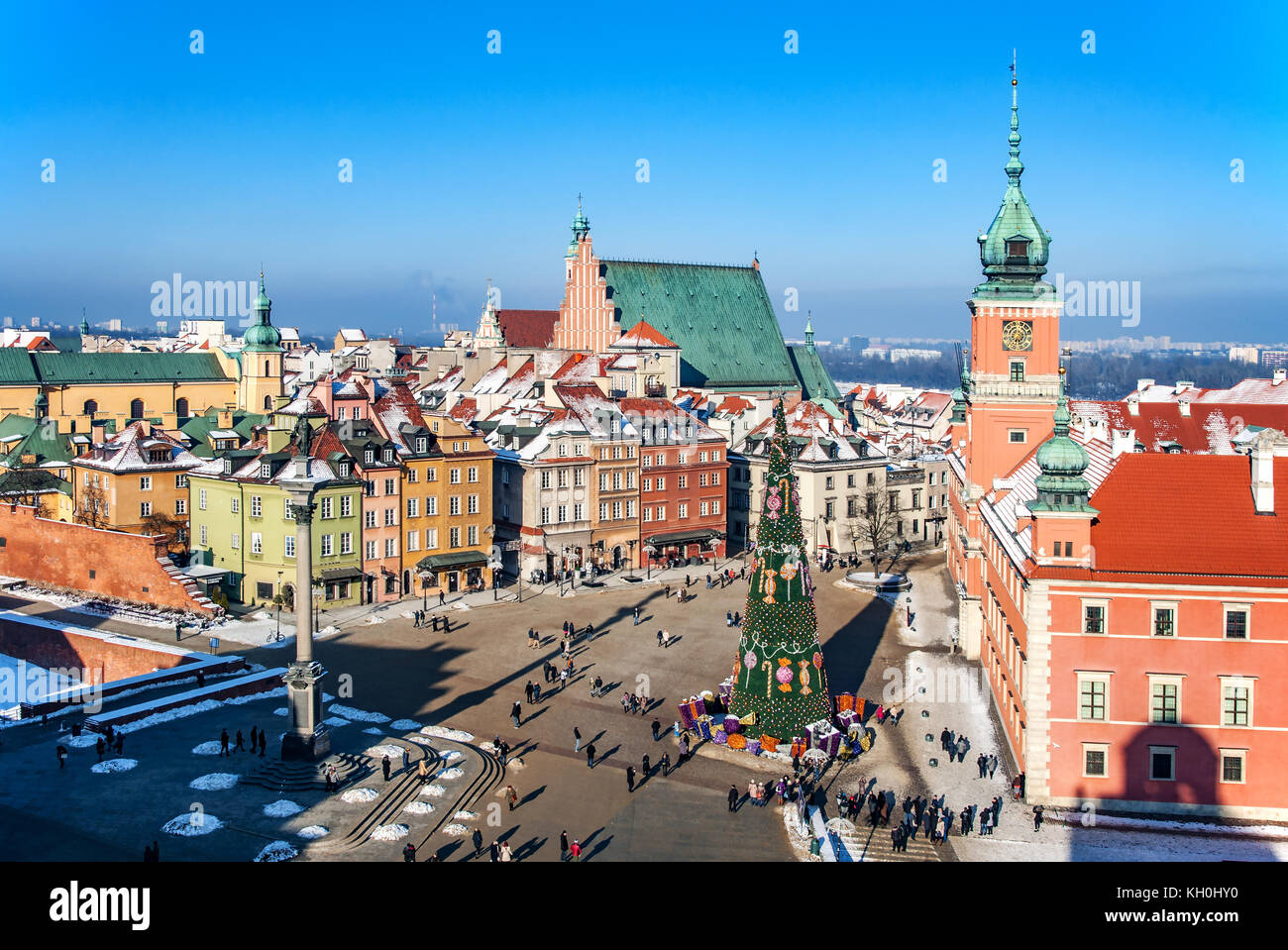 Warsaw old town in winter with Plac Zamkowy (Castle Square), Christmas tree with gifts, Cathedral, Royal Castle, Sigismund's Column and walking people Stock Photo