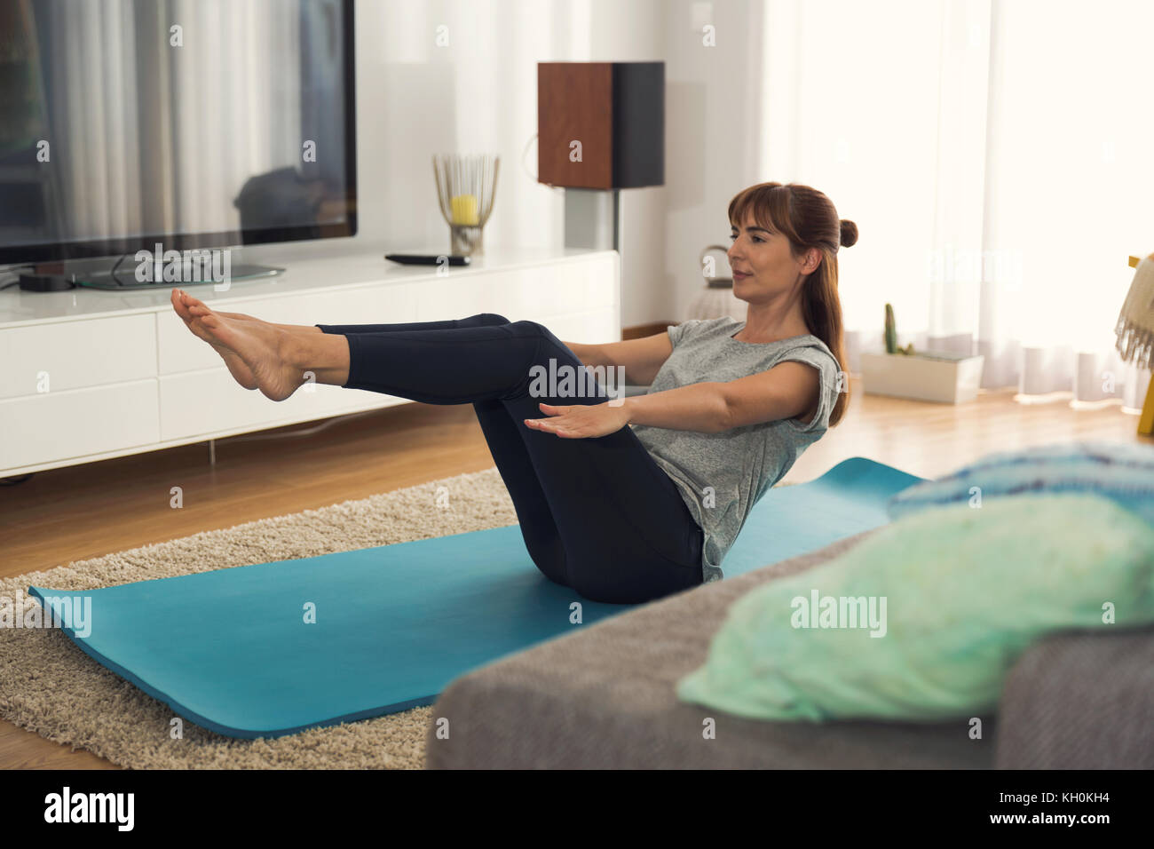 Full length shot of a woman doing exercise at home Stock Photo