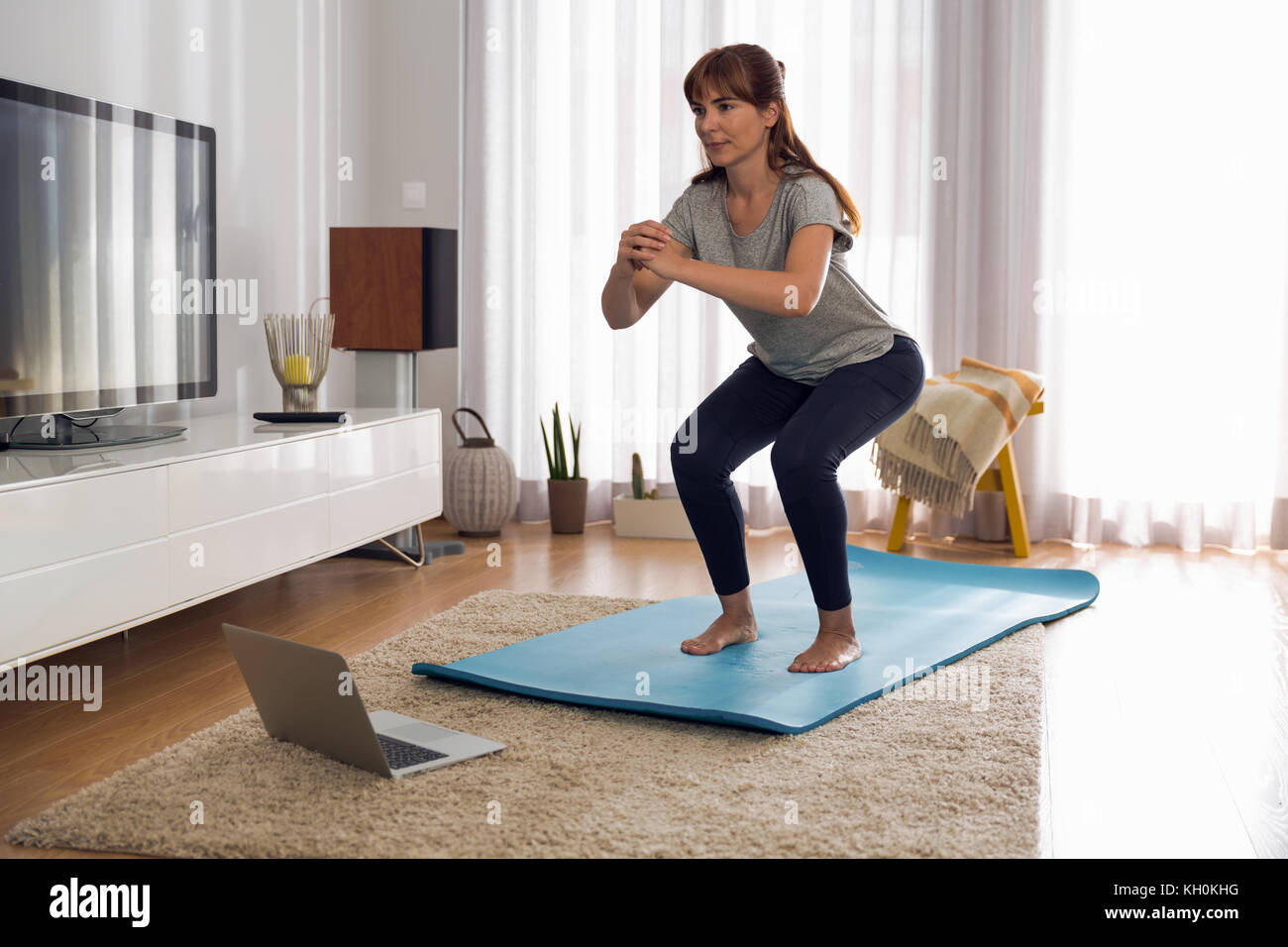Full length shot of a woman doing exercise at home Stock Photo - Alamy