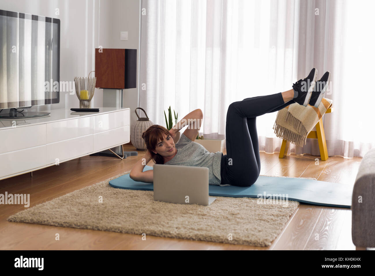 Full length shot of a woman doing exercise at home Stock Photo - Alamy