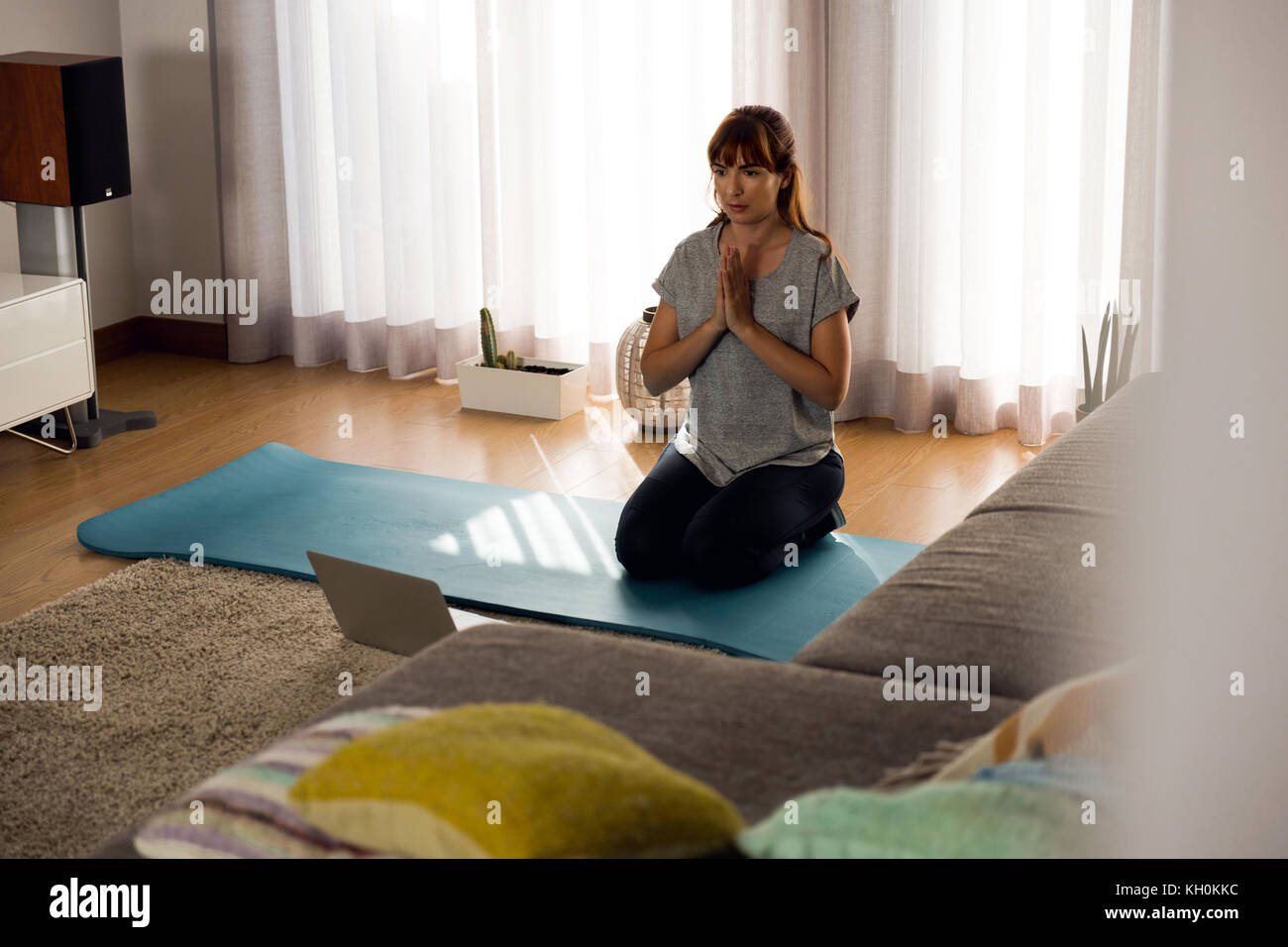 Full length shot of a woman doing yoga at home Stock Photo - Alamy