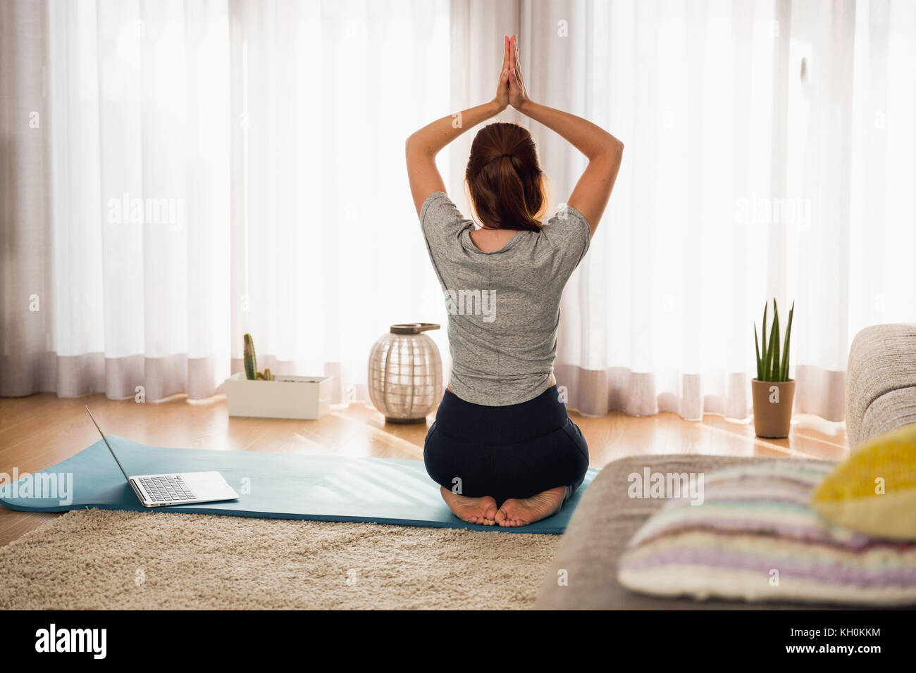 Full length shot of a woman doing yoga at home Stock Photo - Alamy