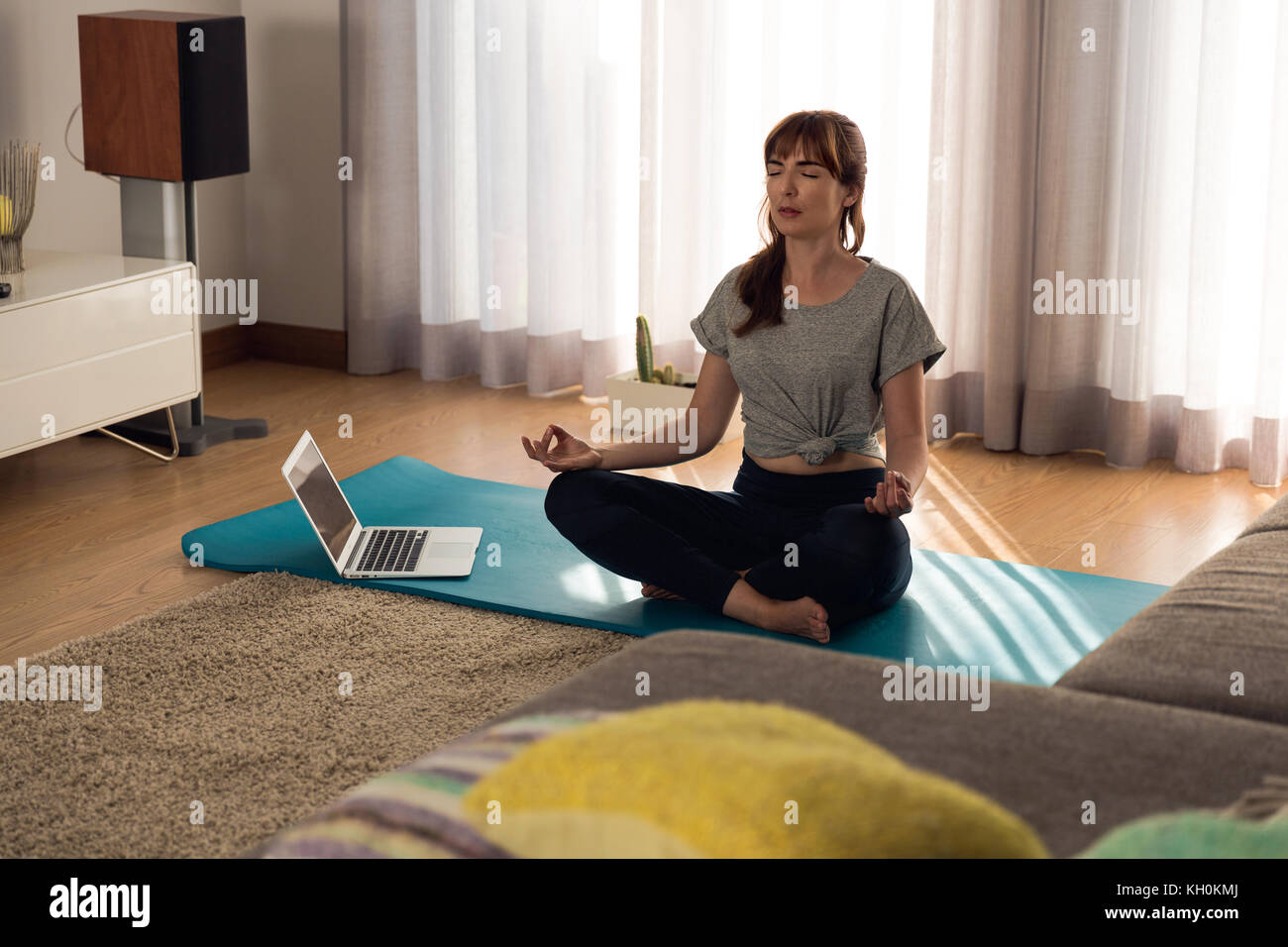 Full length shot of a woman doing yoga at home Stock Photo - Alamy