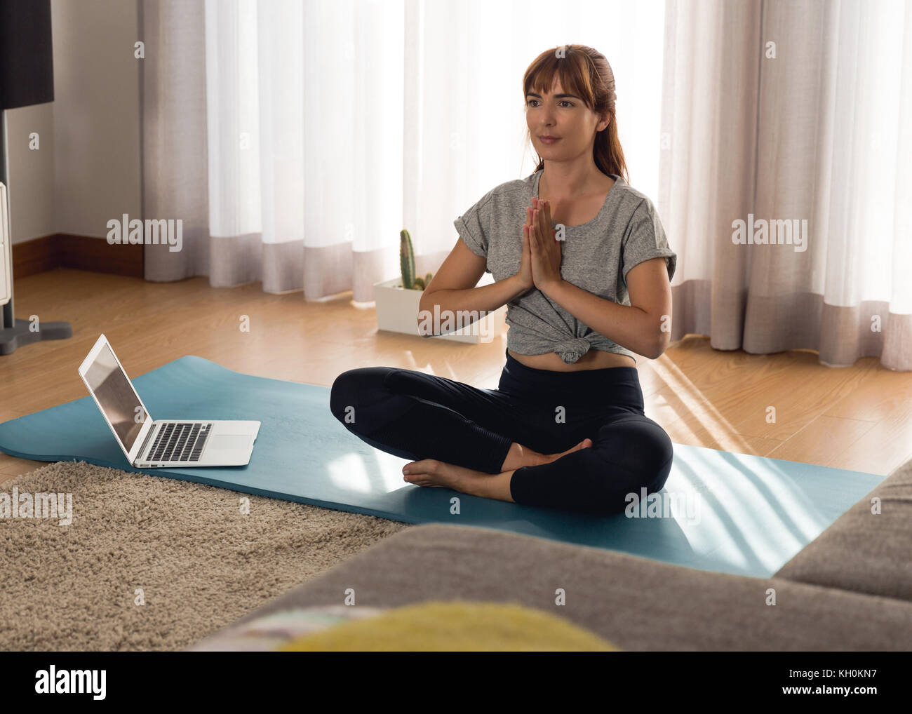 Full length shot of a woman doing yoga at home Stock Photo - Alamy