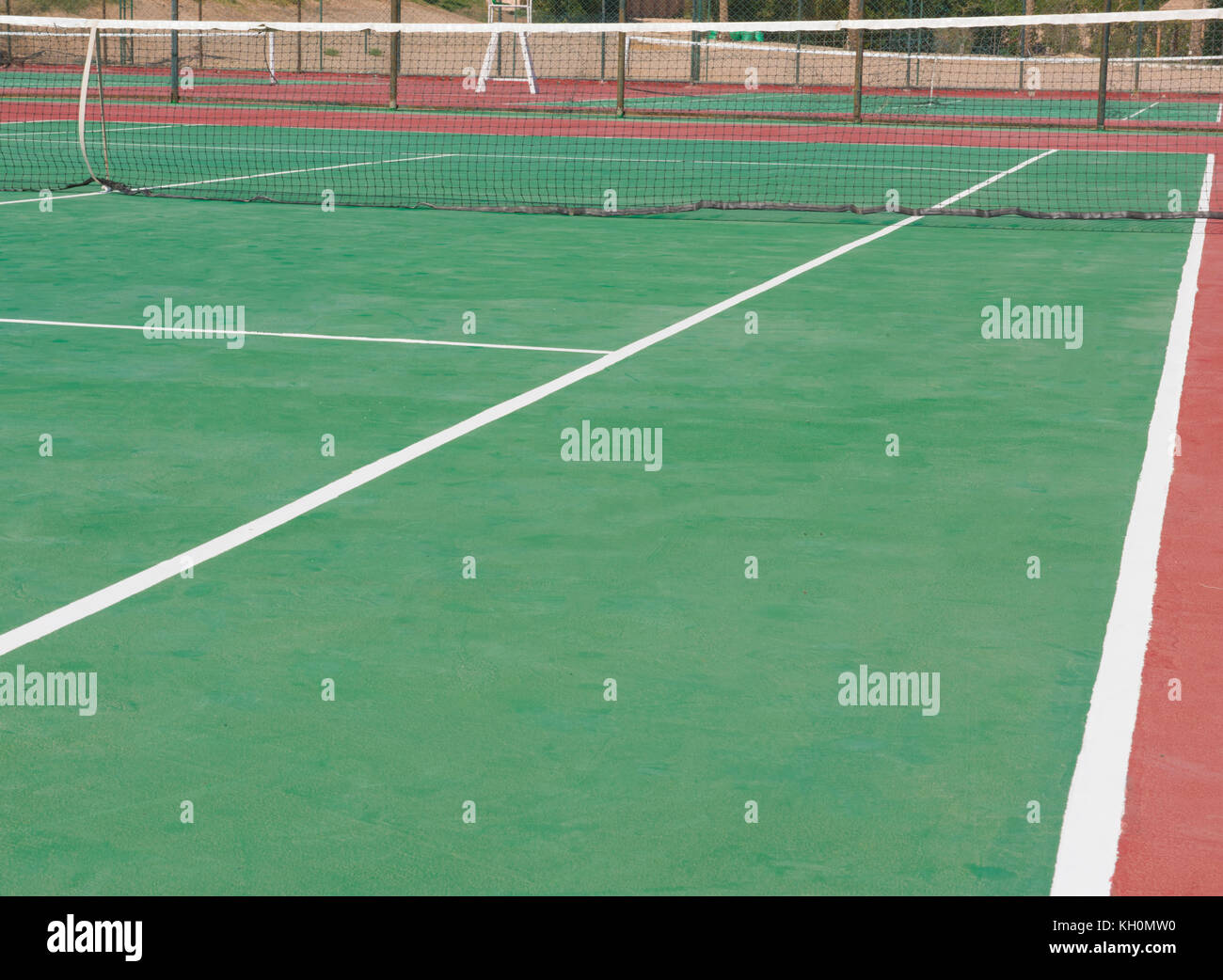 Abstract closeup image of outdoor clay tennis court with green surface and net at tropical hotel holiday resort Stock Photo