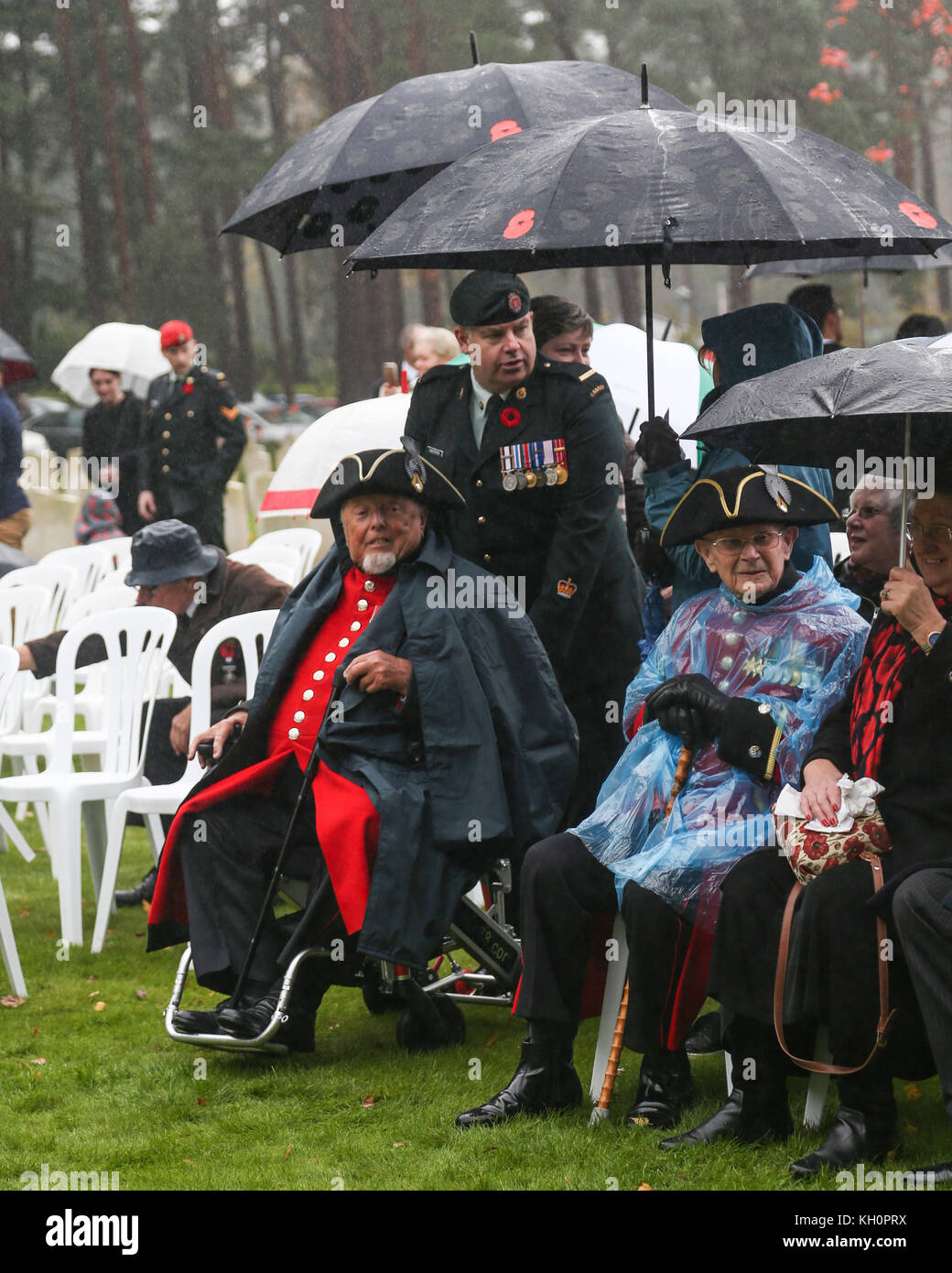 Two Chelsea Pensioners wait in the rain for the start of the Canadian Service of Remembrance at Brookwood CWGC Cemetery in Surrey on Armistice Day Stock Photo